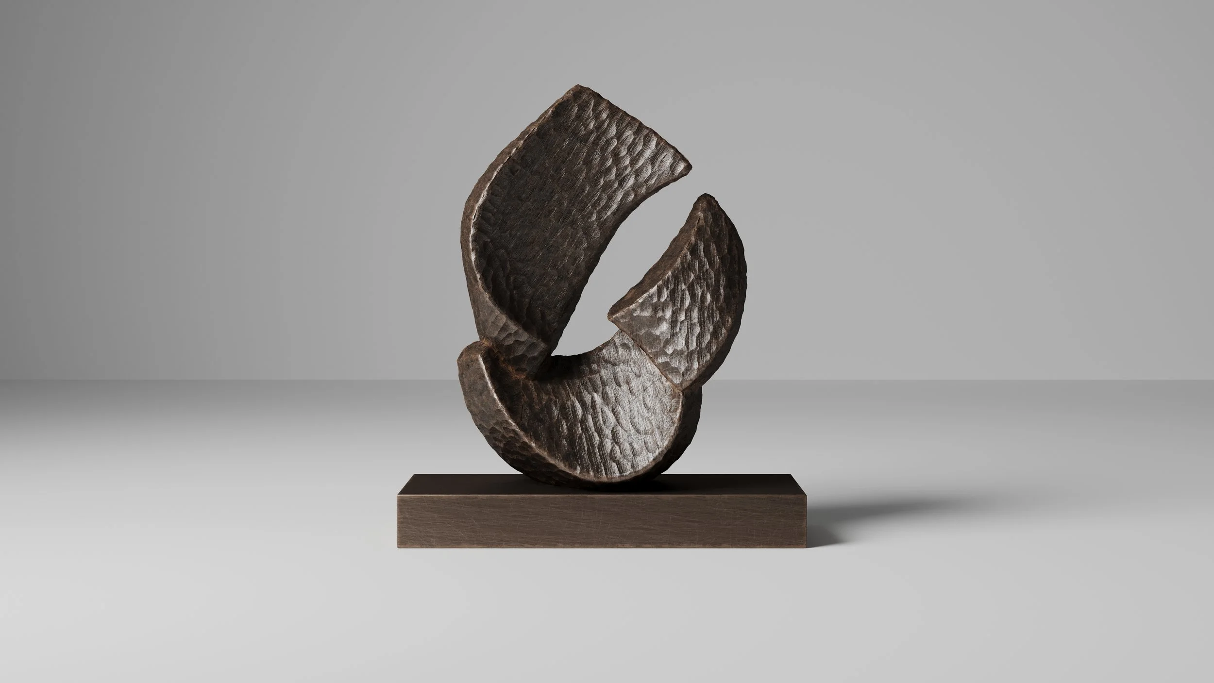 A modern bronze sculpture made of three textured, dark brown, semi-circular pieces stacked on a rectangular bronze base, displayed against a plain gray background.