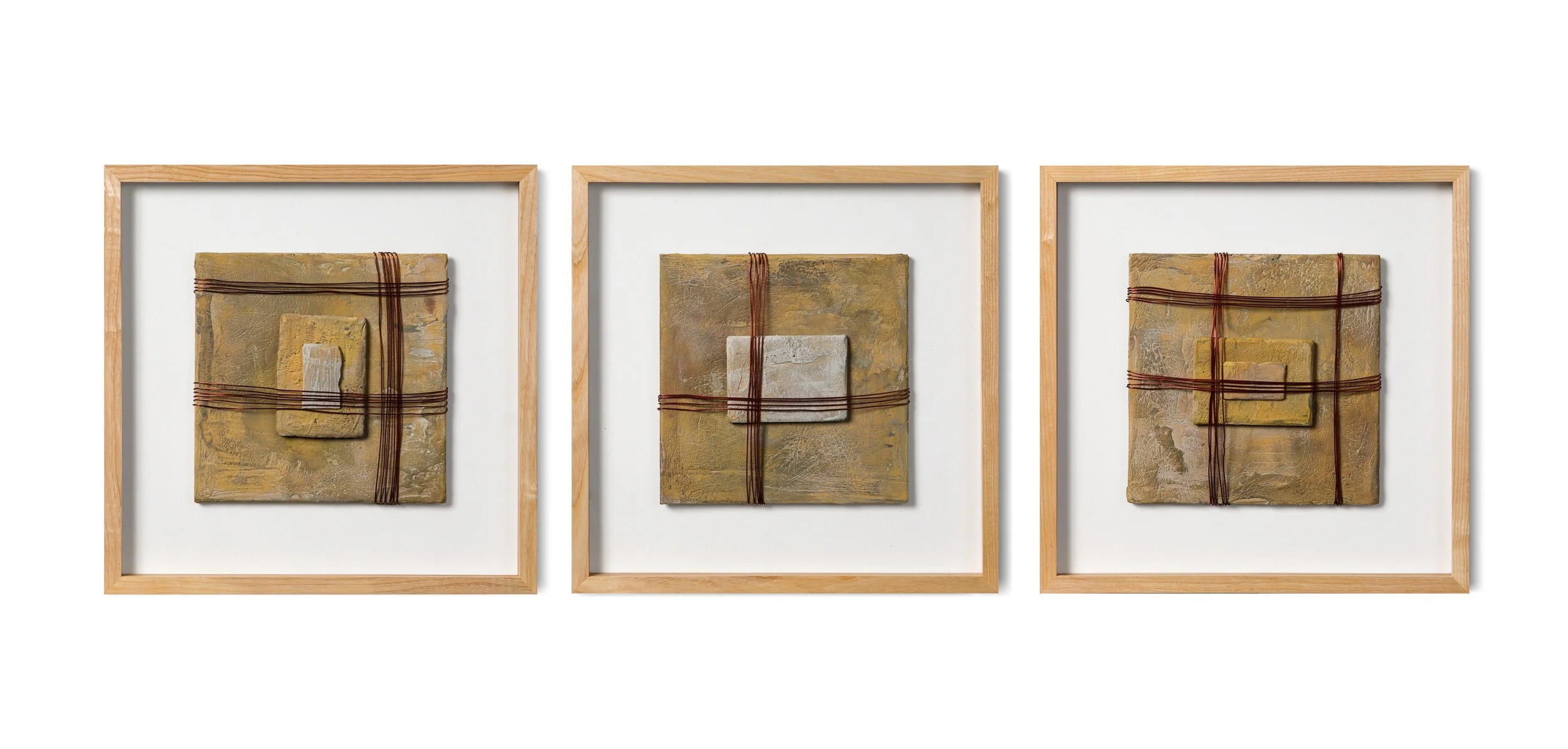 Three framed abstract artwork pieces with textured, layered surfaces and red string wrapped across each, mounted on a white background.