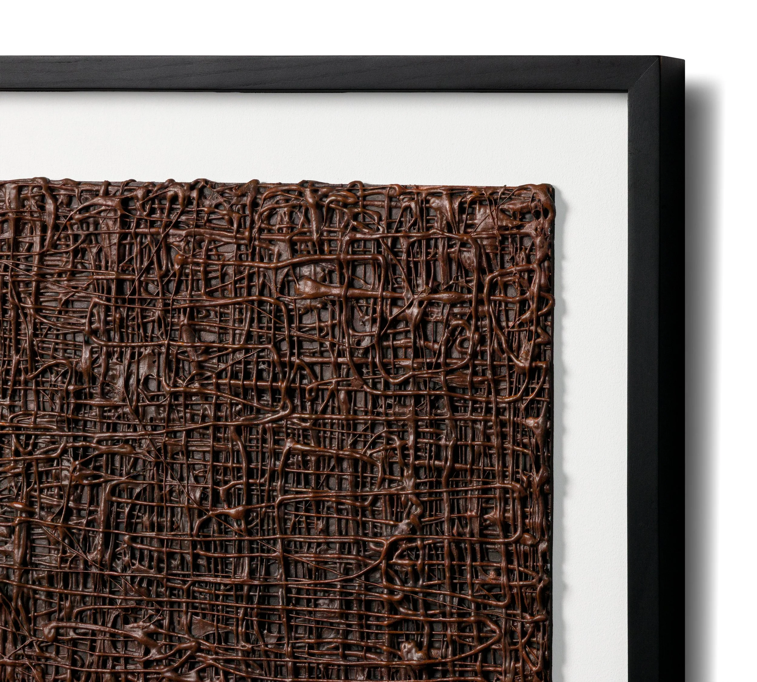 Close-up of a piece of abstract art with an intricate, textured, dark brown interwoven pattern framed in black.