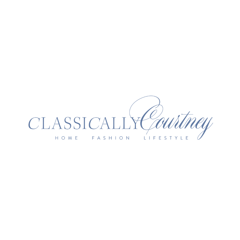 Logo with the text 'Classically Courtney' in blue elegant font, with a stylized 'C' in a script font, and smaller text 'Home Fashion Lifestyle' underneath.