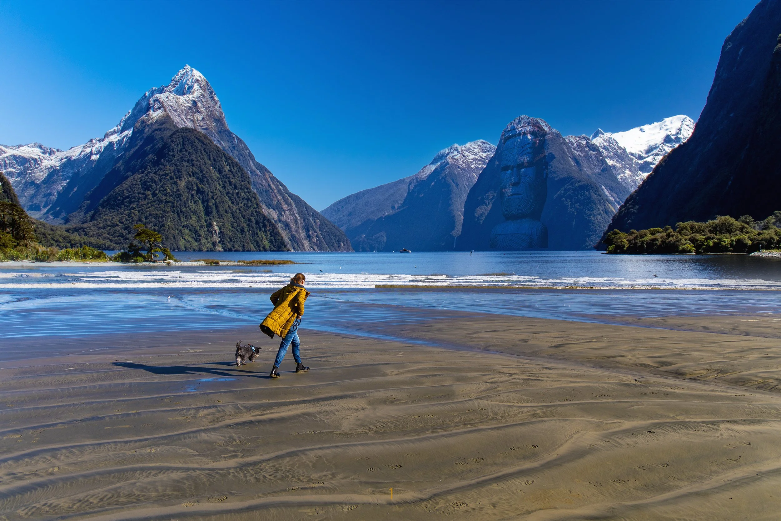 An image of a woman and dog on a beach with Mitre Peak as the back drop.