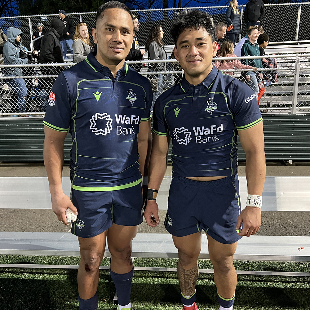 Two young male athletes posing together at the end of a rugby match. This is their fist game playing together since their recovery from surgical procedures.