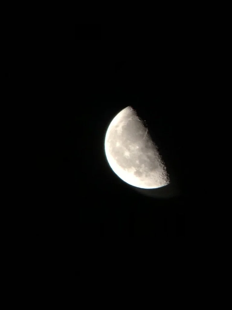 A photograph of the moon in its waxing crescent phase against a black night sky.