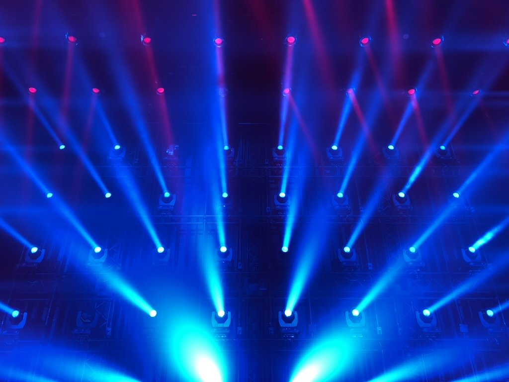 Stage lighting with blue and pink spotlights shining upward.