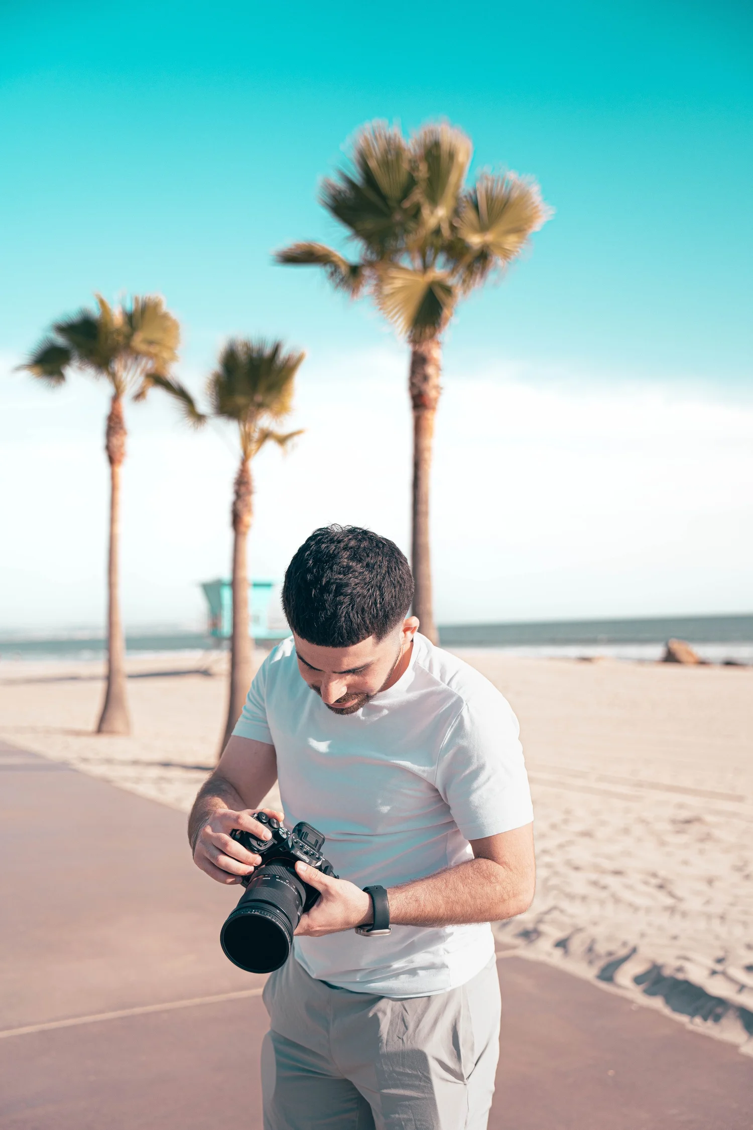 Sam holding a camera on the beach