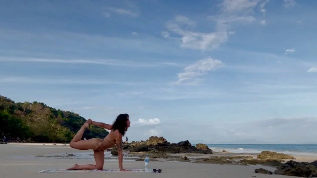 Corrie practicing yoga on the beach in Thailand