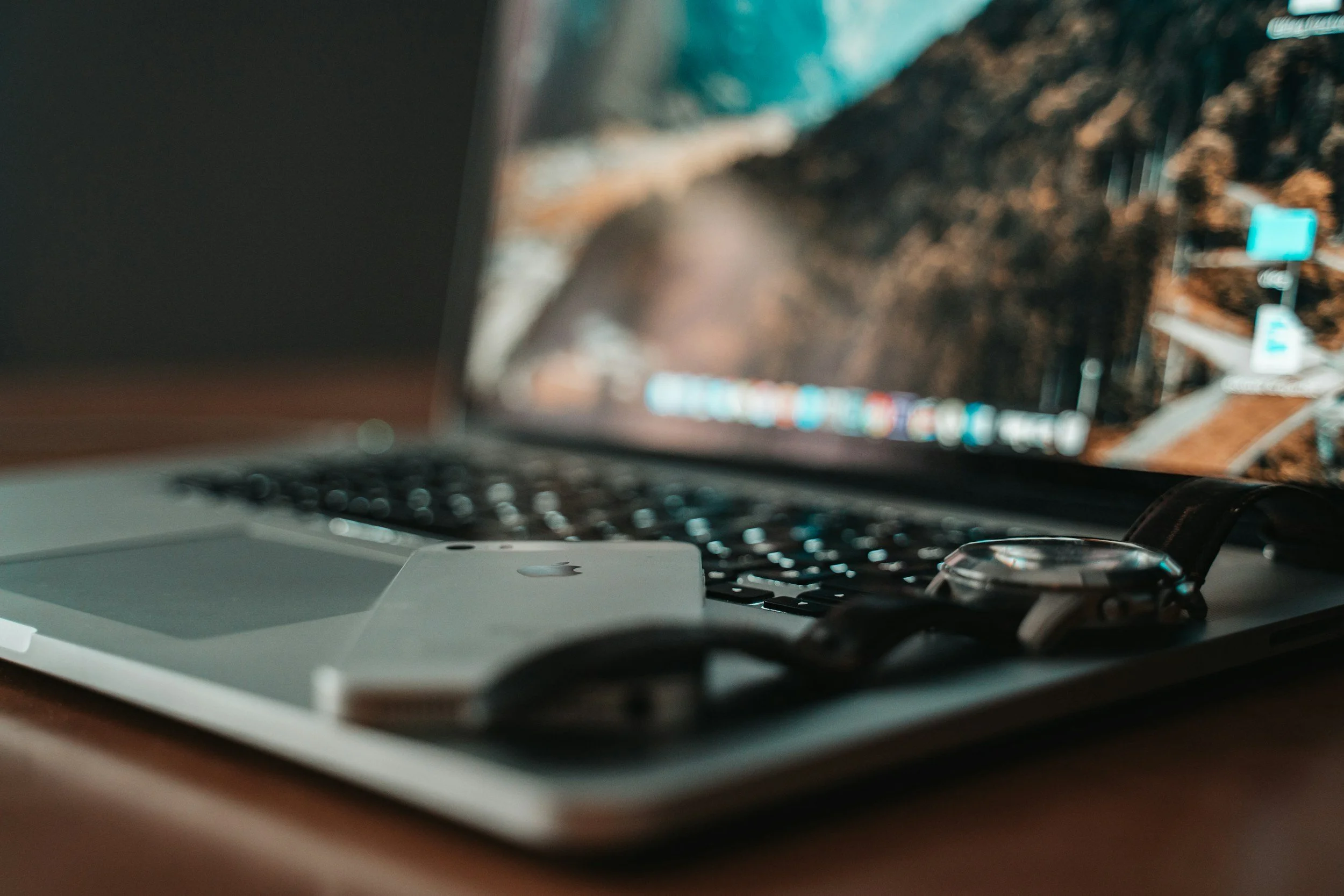 Photo of a computer with a phone and sitting on the keyboard.