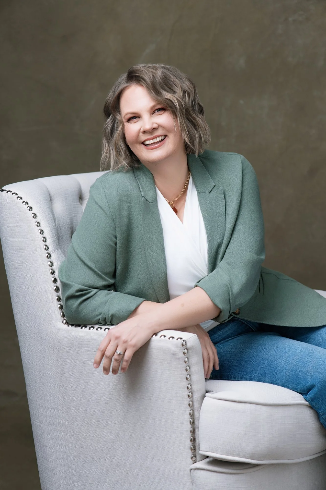 Professional photo of Megan Silberhorn, LPCC, counselor in Fort Collins, sitting in a chair with a smile.