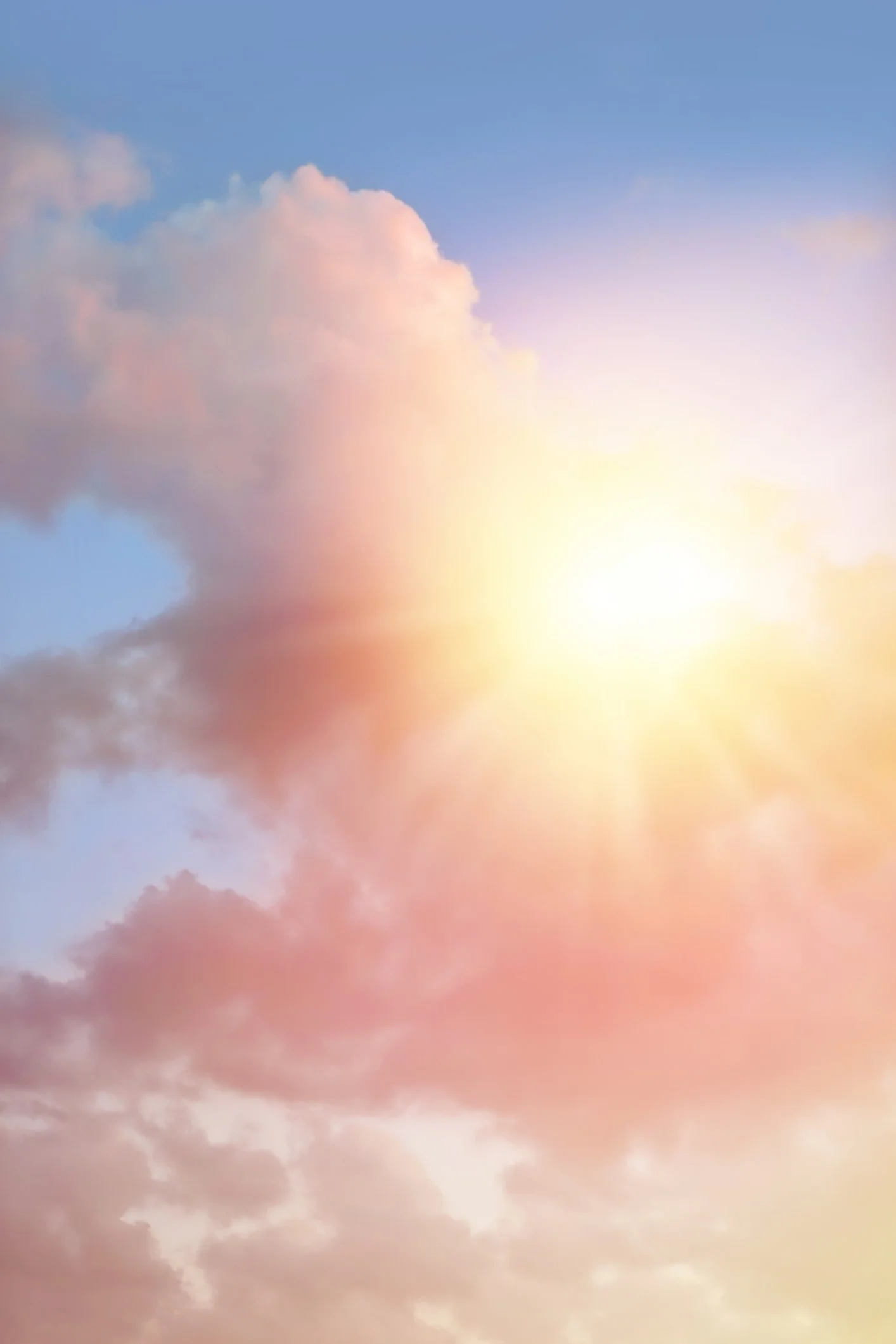 Image of the sun breaking through pink clouds in a light blue sky.