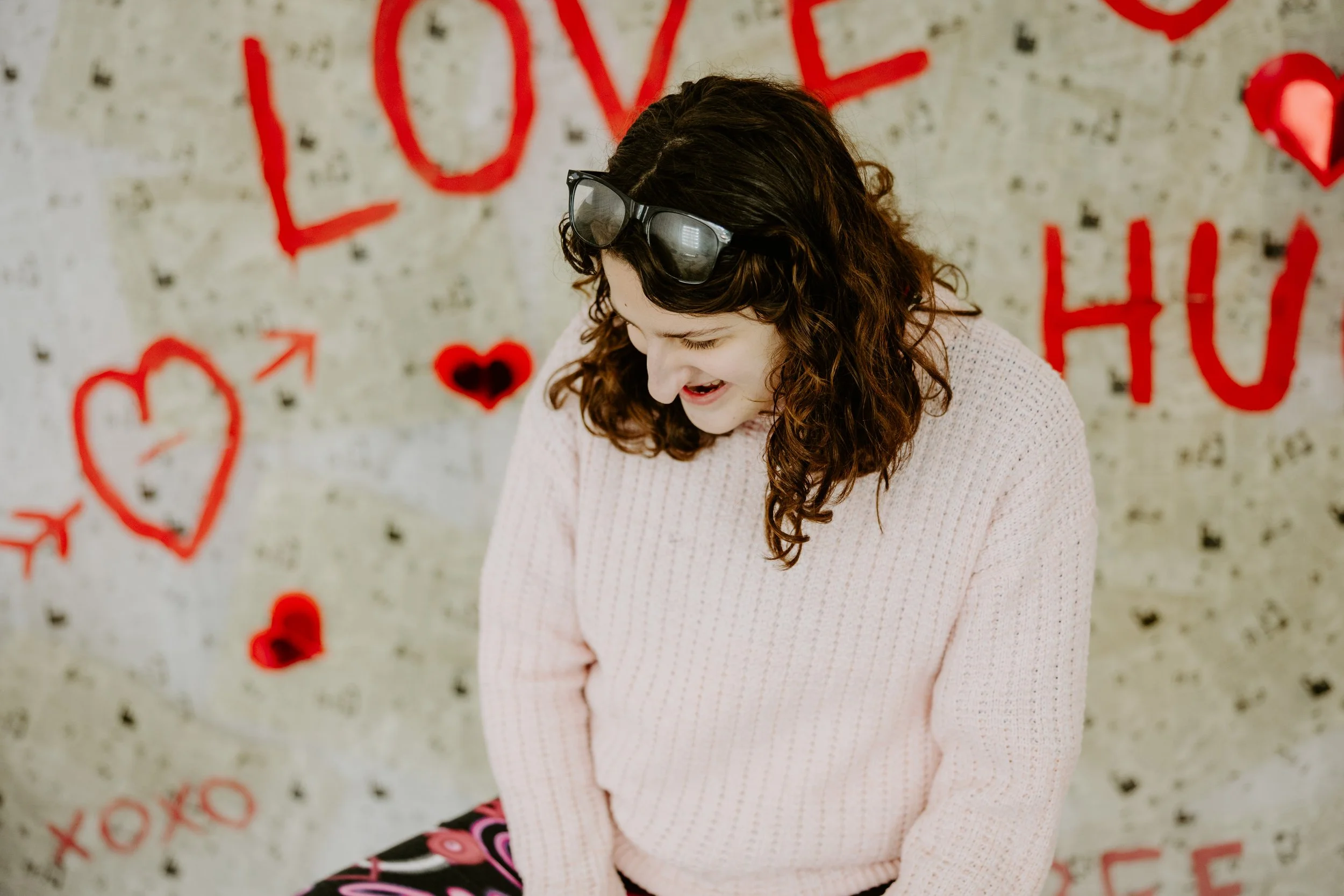 a girl looks down in front of a newspaper backdrop