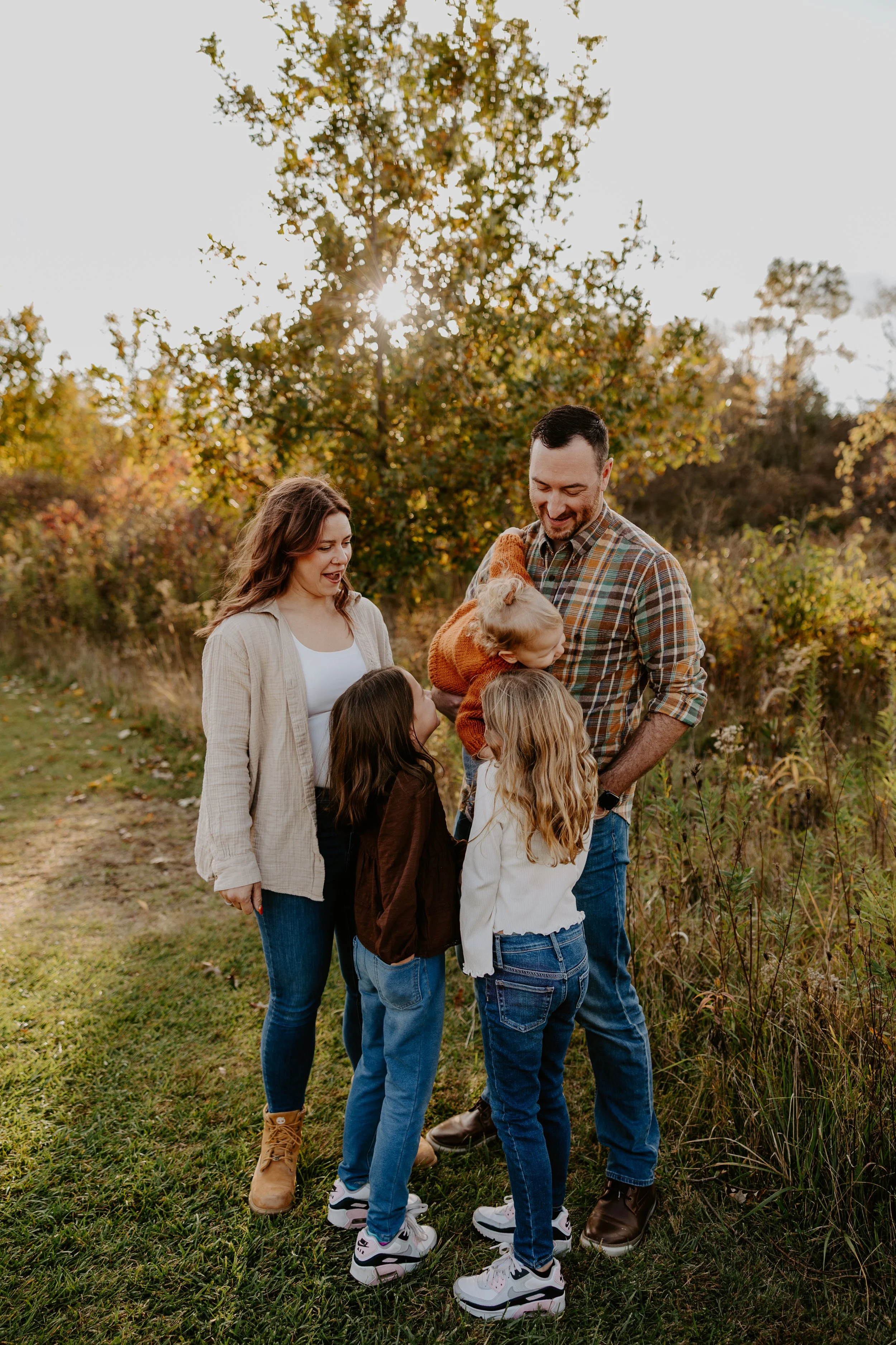 two parents give their daughters piggy back rides