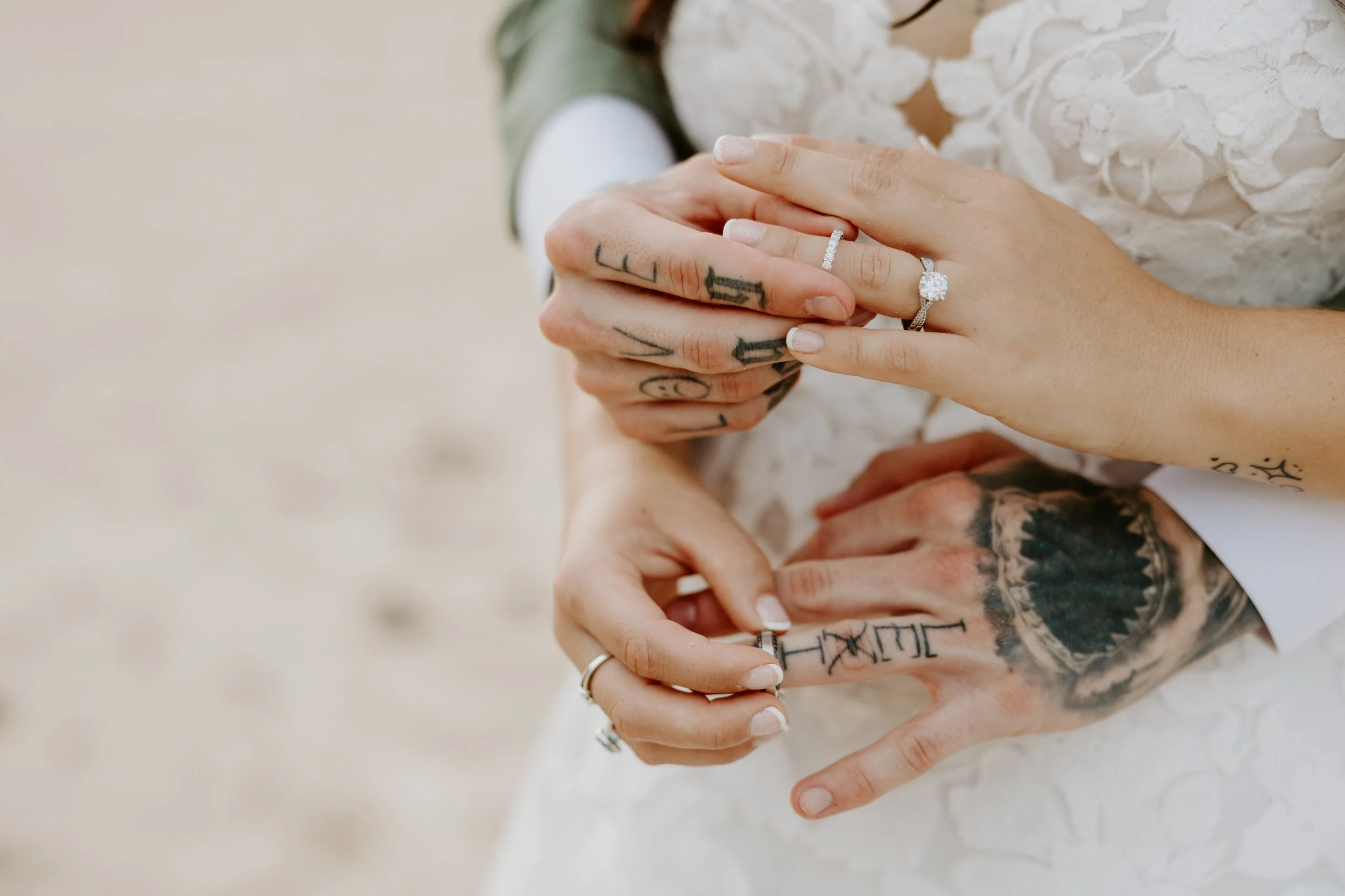 Two sets of hands putting weddings bands on each other