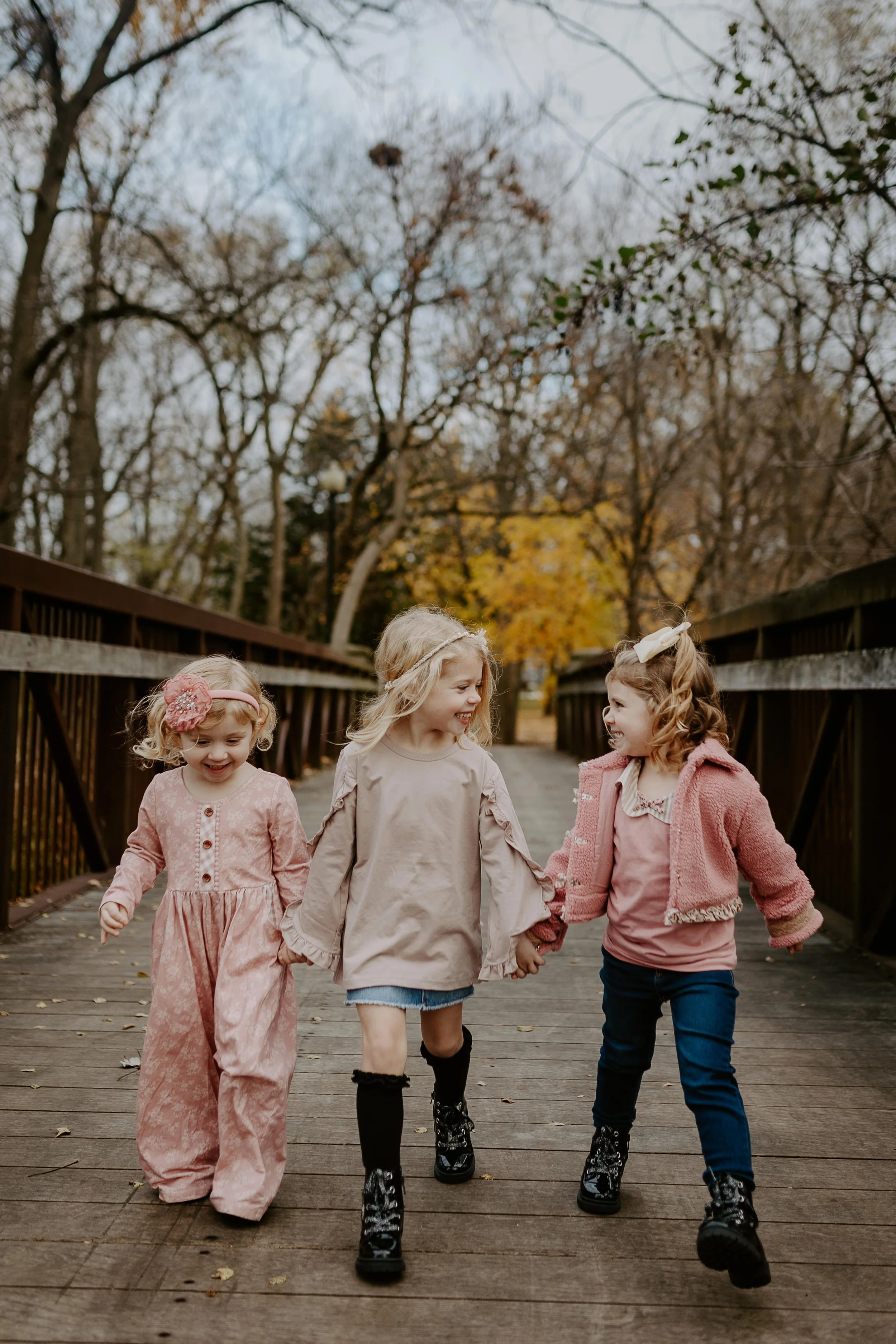 Three sisters hold hands and walk towards the camera