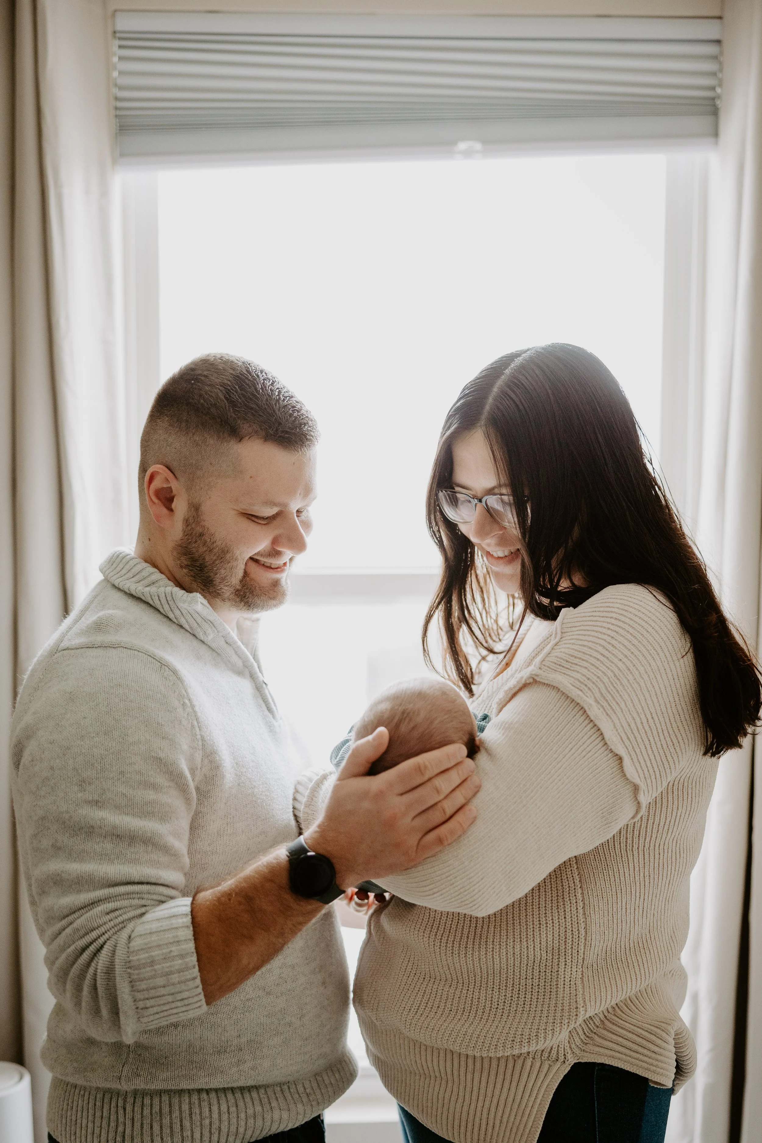 A newborn in a blue pj set yawns
