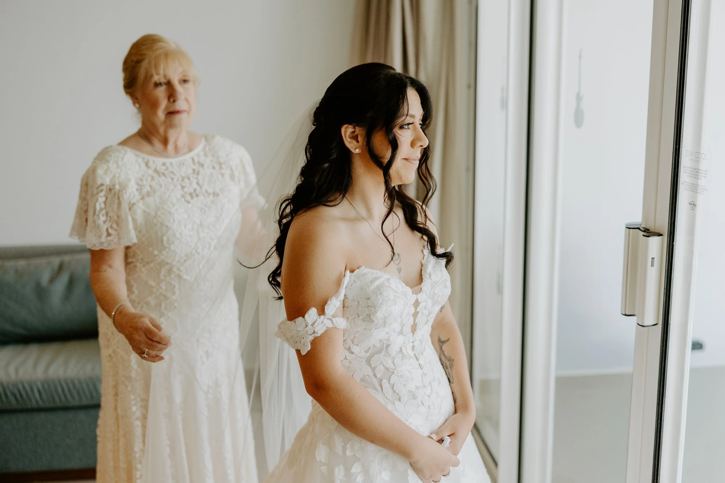 A grandmother helps her granddaughter with her wedding veil