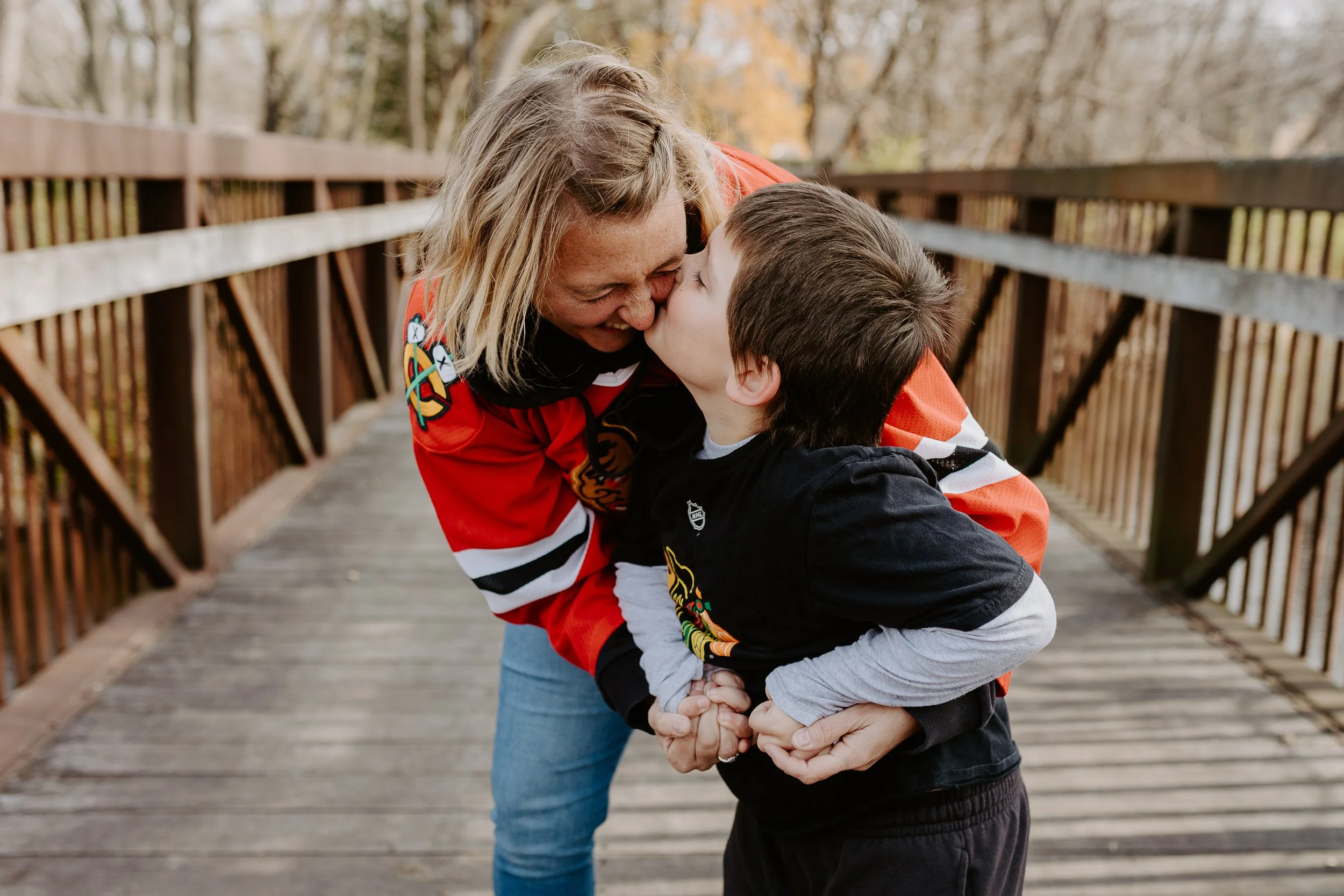 A little boy pulls his mom and dad behind him and playfully sticks his tongue out