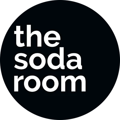 Black circular background with white text that reads 'the soda room'.