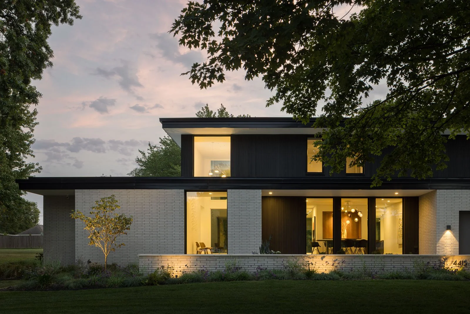 Exterior front facade of Prairie Light residence showcasing modern residential architecture and natural landscaping