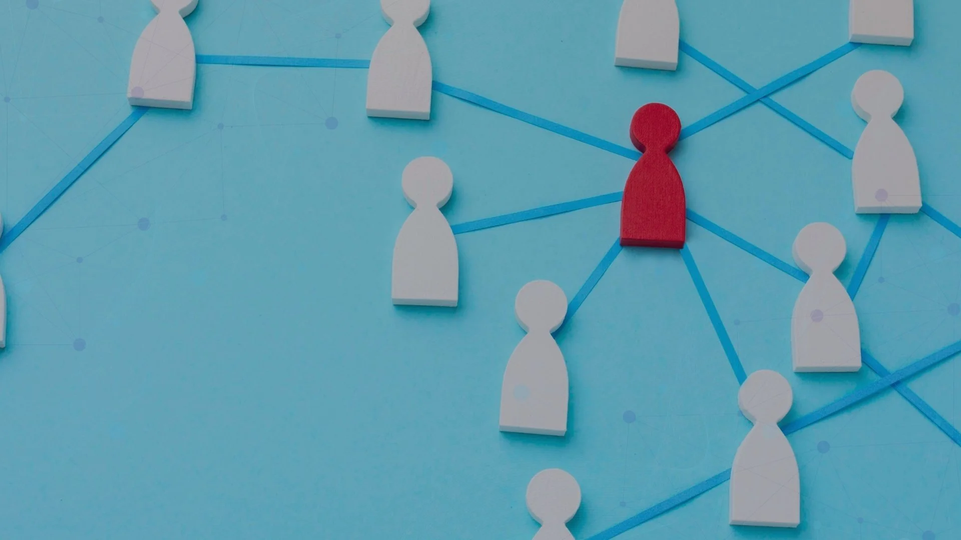 Red wooden figure at the centre of a network of white figures connected by blue lines.