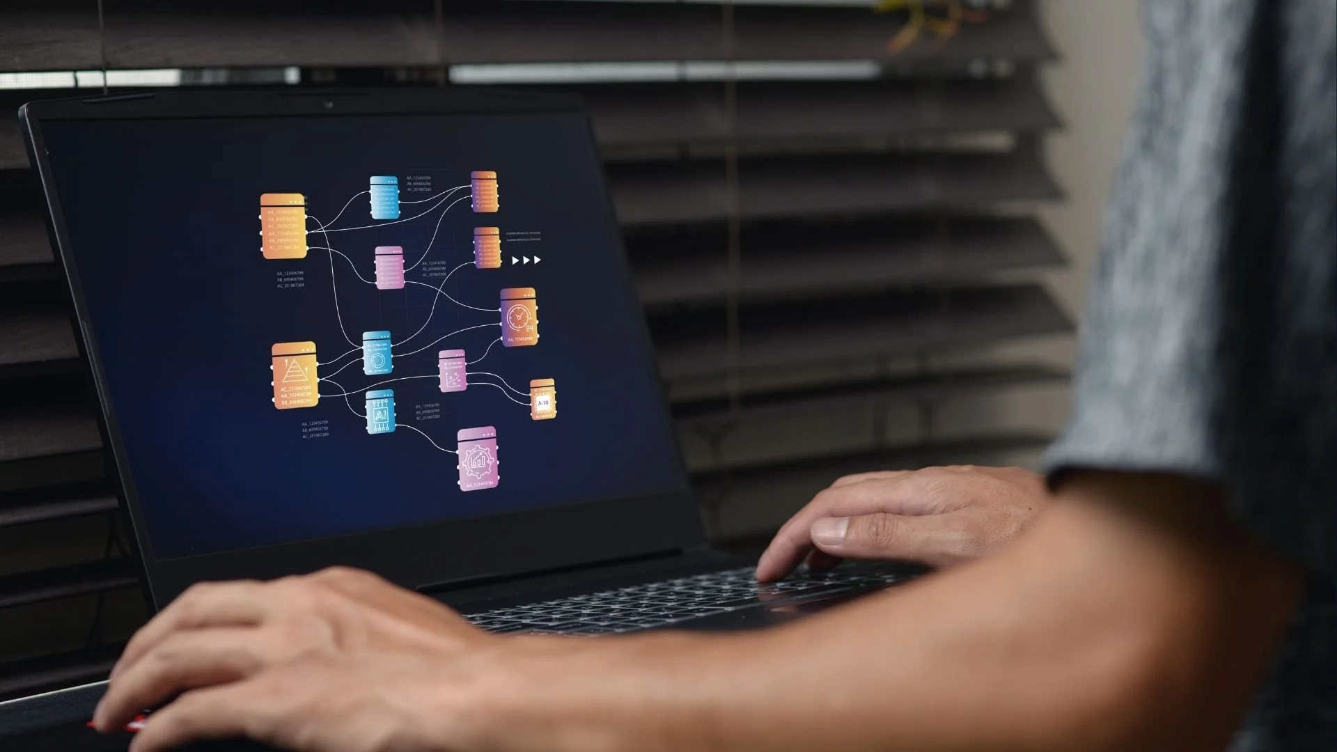 Person working on a laptop displaying a branching AI workflow diagram.