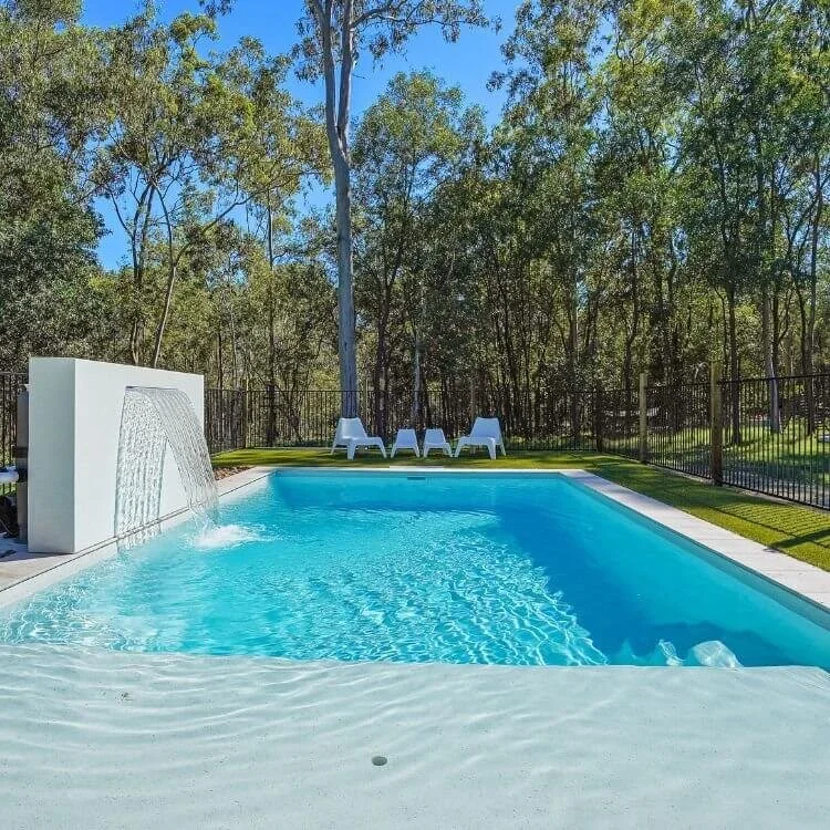 Freedom Pools Beach Pool with waterfall feature and open backyard - available through Plungeit Pools Queensland