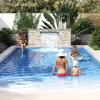 Family enjoying Freedom Pools Beach Pool with stone water feature wall - available through Plungeit Pools Queensland