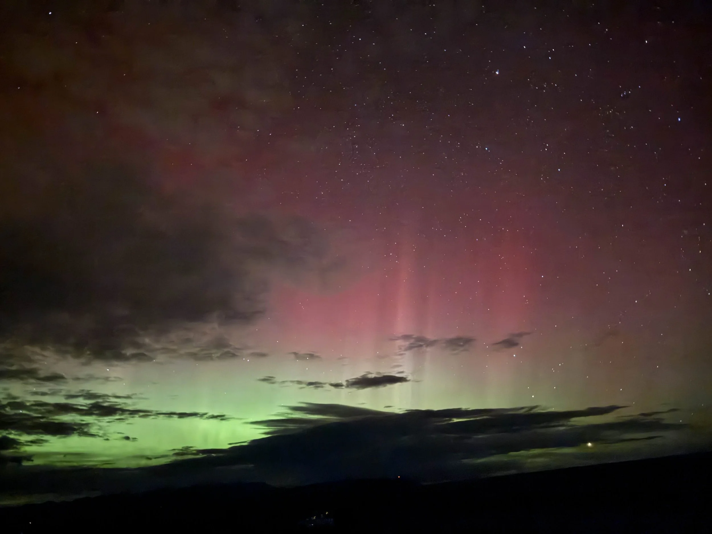Pink and green aurora borealis lighting up the Montana night sky – Cradle of Life LLC