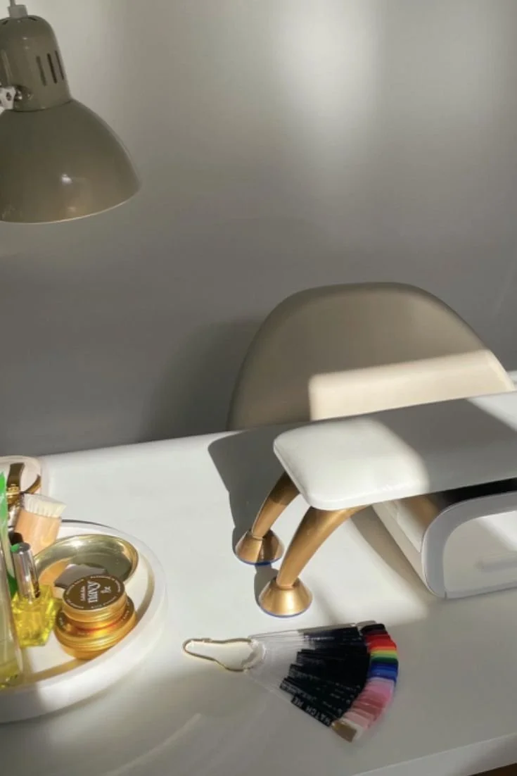 紙や絵の具のサンプルが置かれた机と、椅子、デスクランプ。