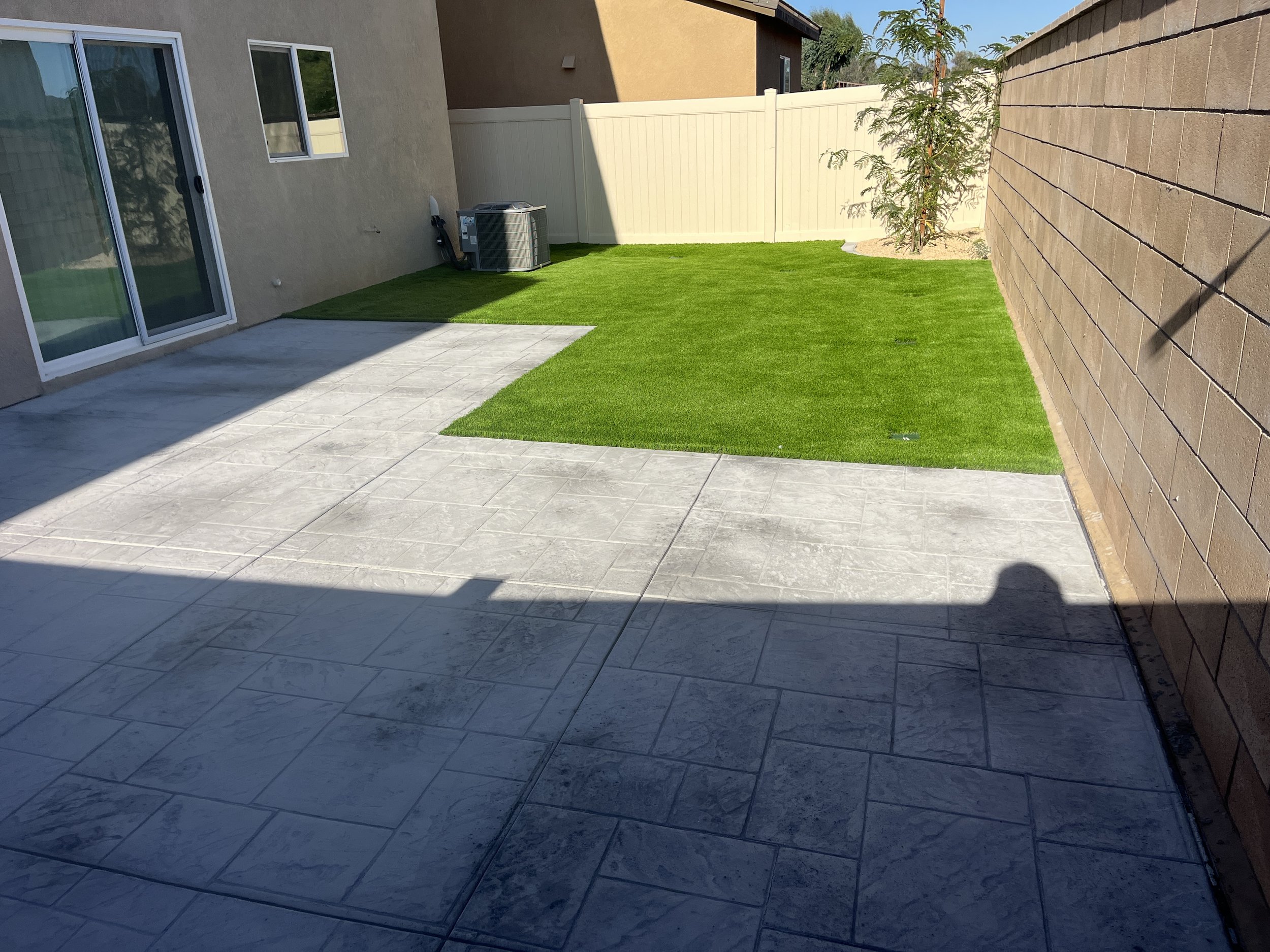 “Residential backyard concrete and turf installation in Menifee