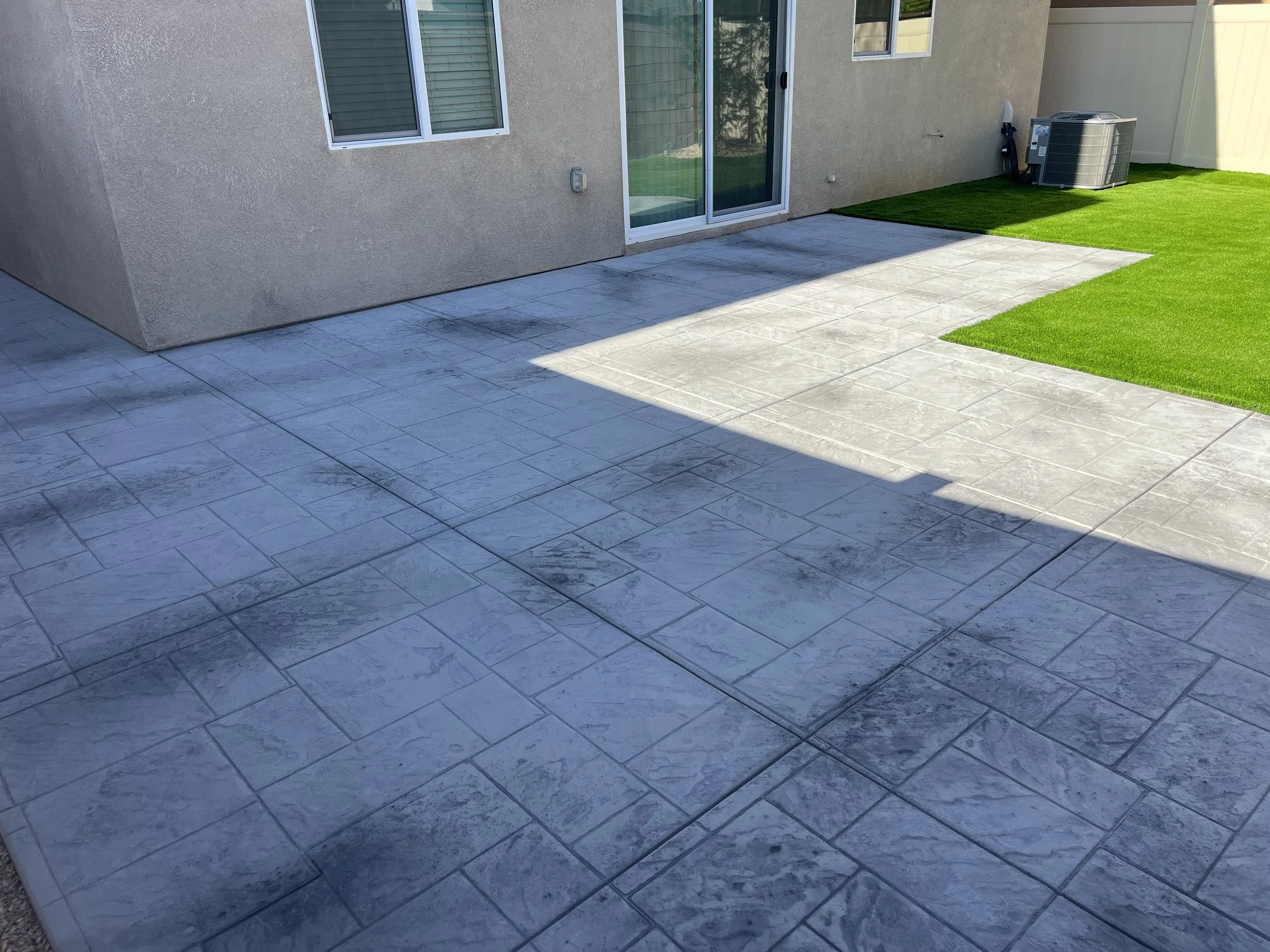 Stamped concrete patio pattern with turf border in Menifee CA