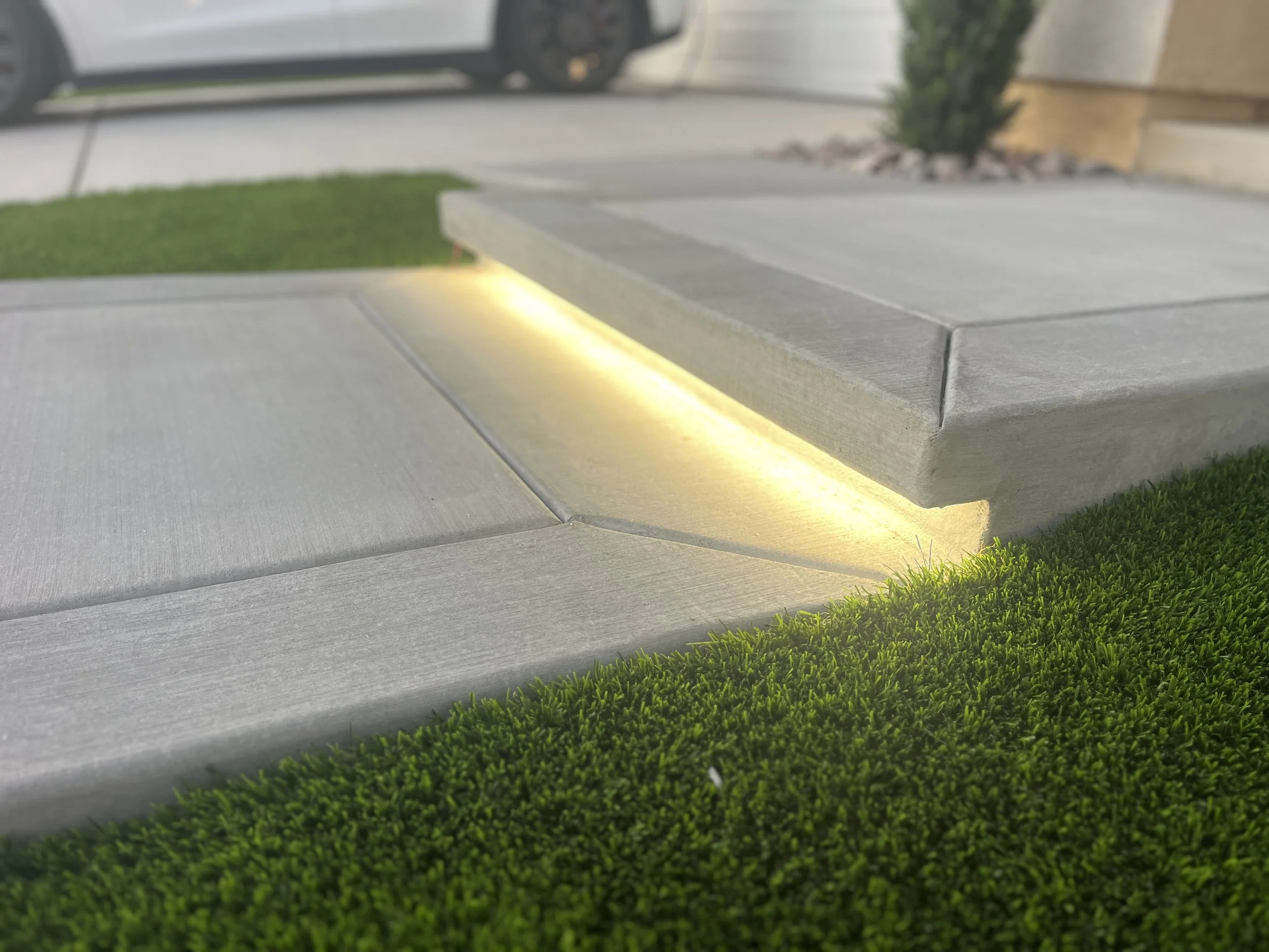Decorative concrete step lighting installed along a modern front walkway in Murrieta.