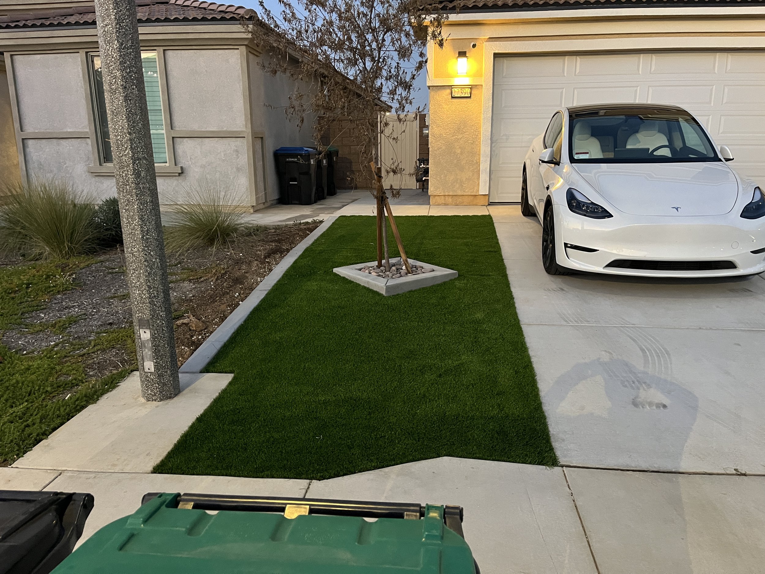 Concrete walkway edge detail with artificial turf border in Murrieta, California.