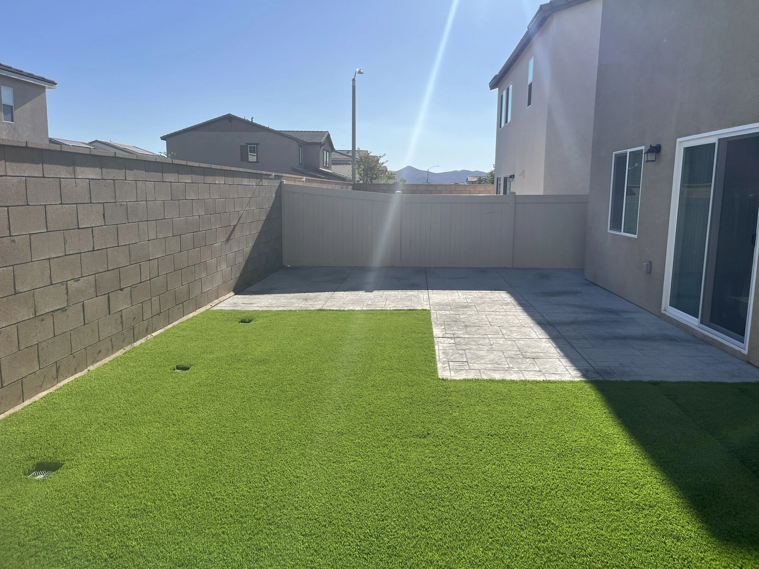 Stamped color concrete patio with artificial turf installation