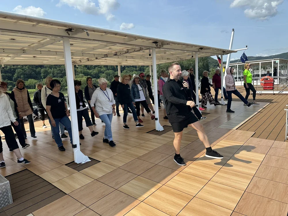 Menschen auf einem Bootsdach tanzen während einer Führung oder Veranstaltung.