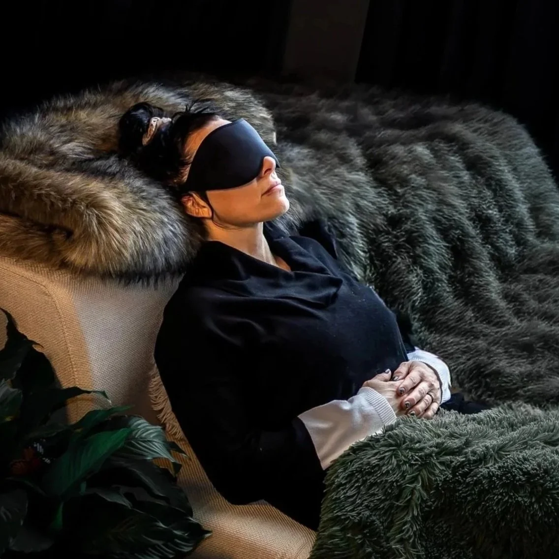 Woman on couch, comfortable with eye shades getting her first ketamine therapy injection treatment