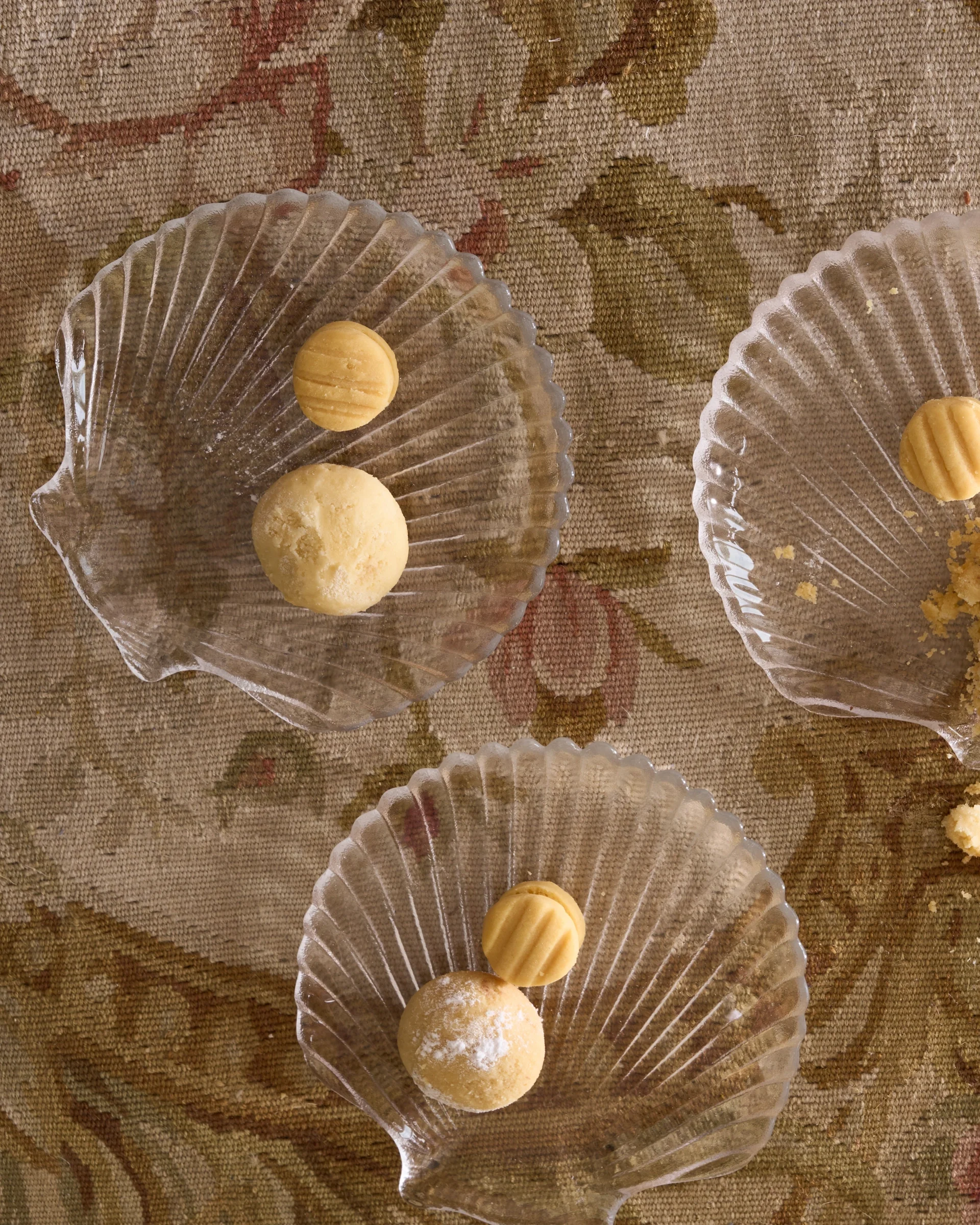 a top-down view of three clear, glass shell-shaped plates