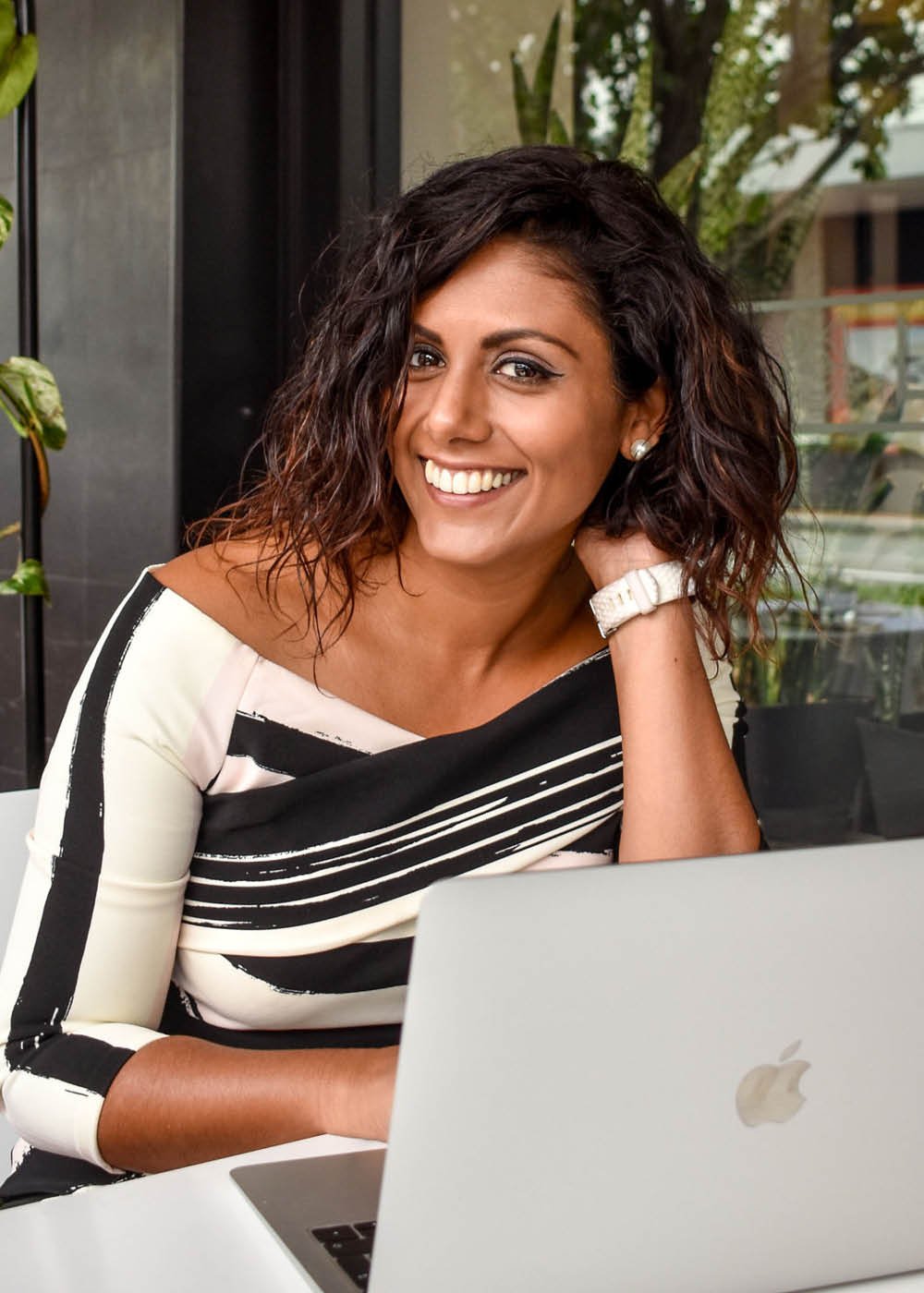 Amanda Louisa, feminine embodiment coach and energy healer on her laptop