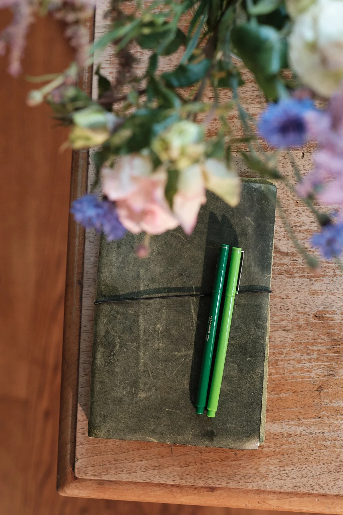 Notizbuch und Stifte auf Holz – Vorbereitung auf Psychotherapie-Sitzung in Wien.
