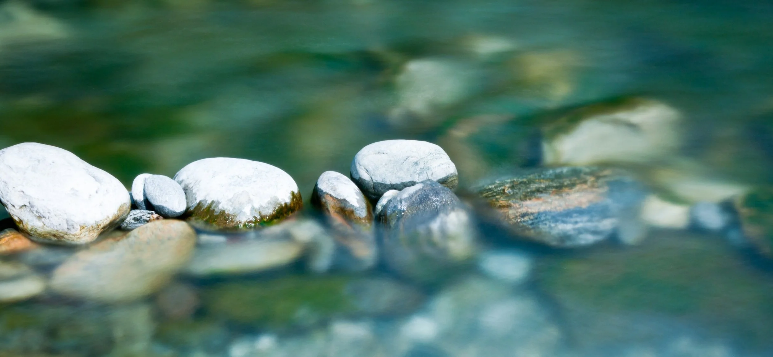 Pierres blanches et grises dans l'eau transparente d'une rivière.
