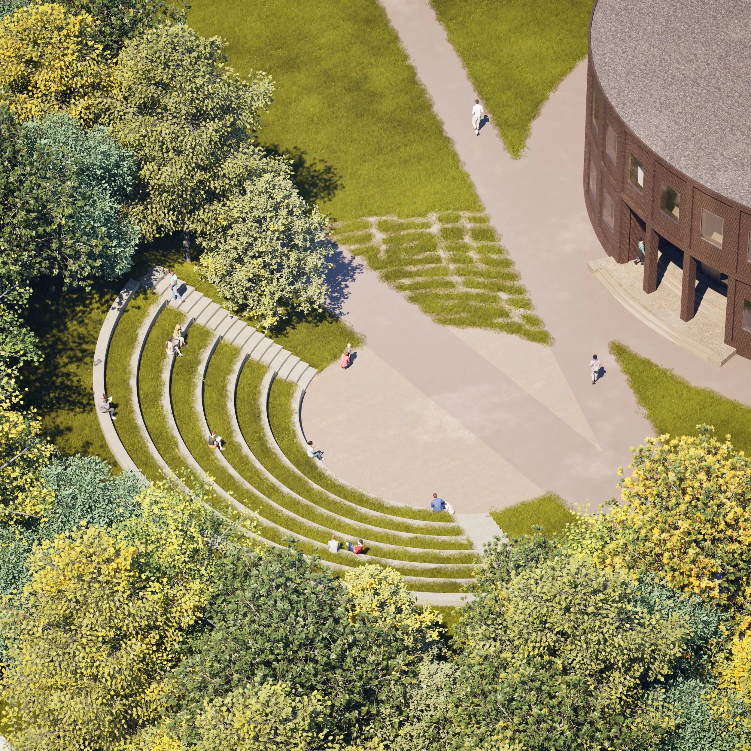 An aerial view of an outdoor amphitheater with curved concrete steps surrounded by trees, grassy areas, and pathways. People are sitting and walking around the area next to a large brick building.