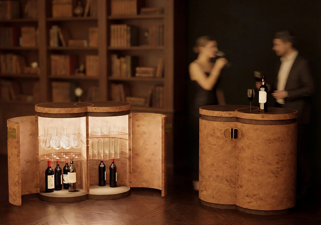 A wooden bar with bottles of wine and glasses, two people in formal attire, a woman and a man, talking and holding wine glasses in the background, in a dimly lit room with a bookshelf.