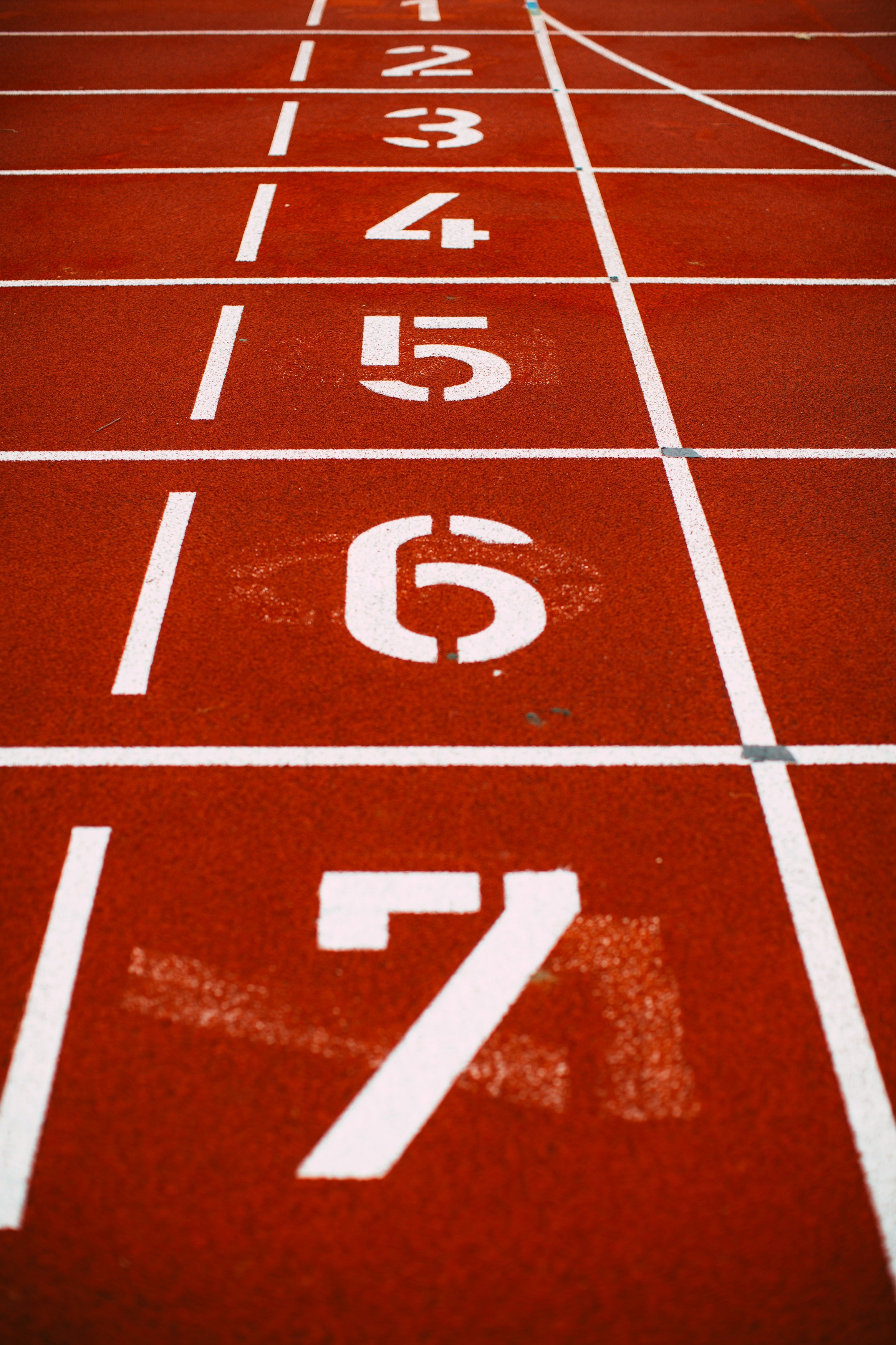 A man with glasses and a beard, wearing a graphic T-shirt, standing indoors near colorful sticky notes on a glass wall.