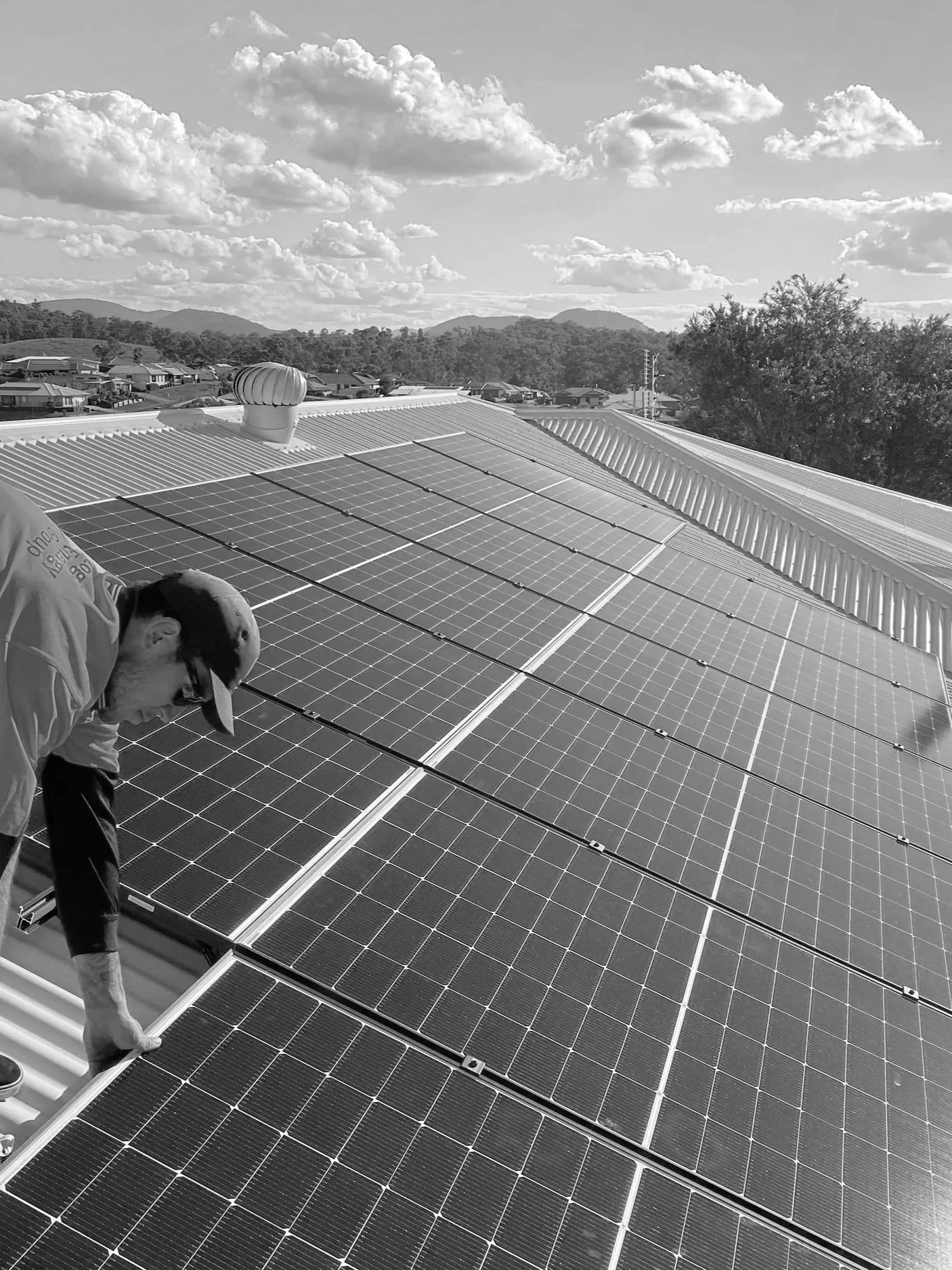 A person inspecting solar panels on a rooftop.