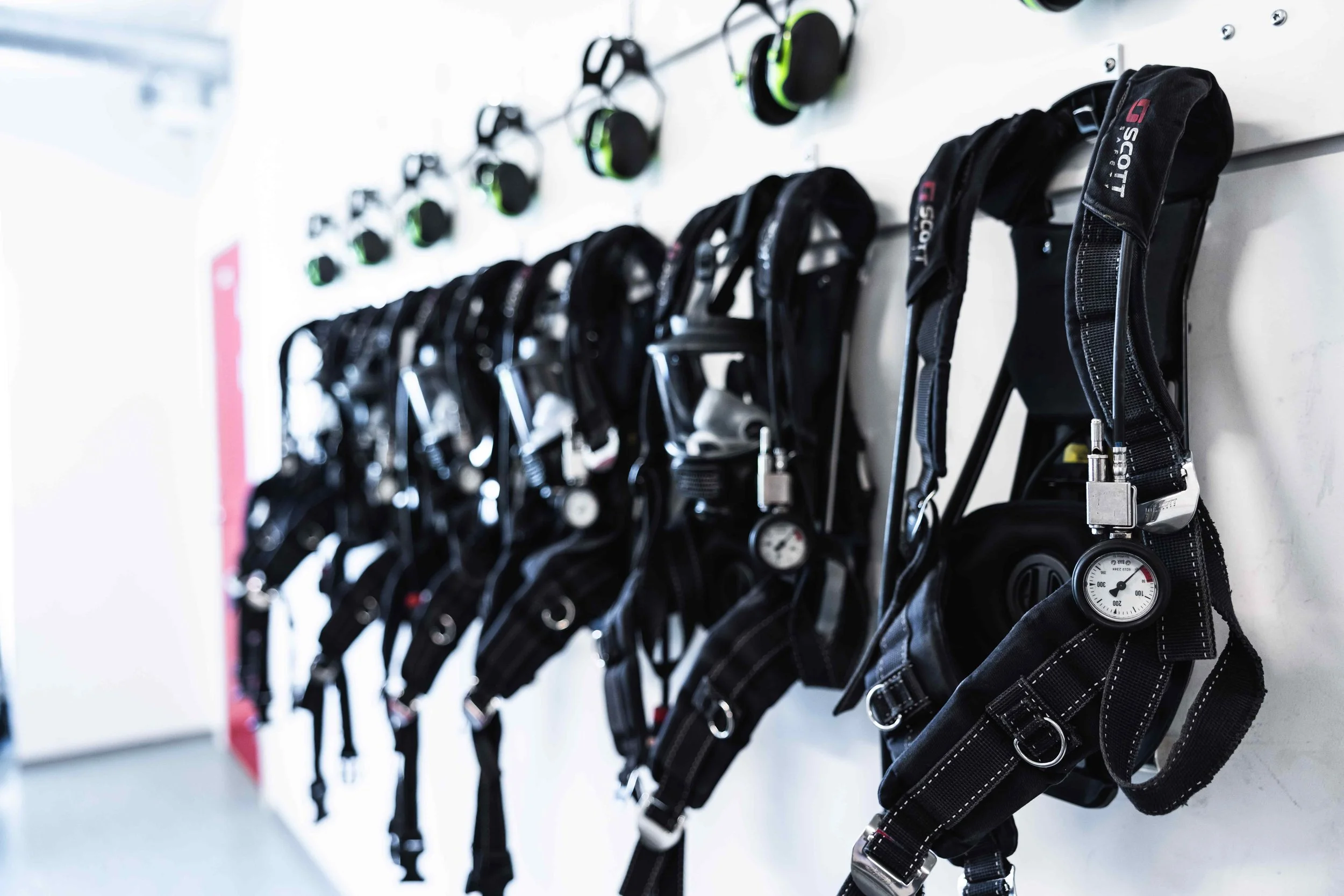 Brannmenn i fullt verneutstyr foran en brann med store flammer.