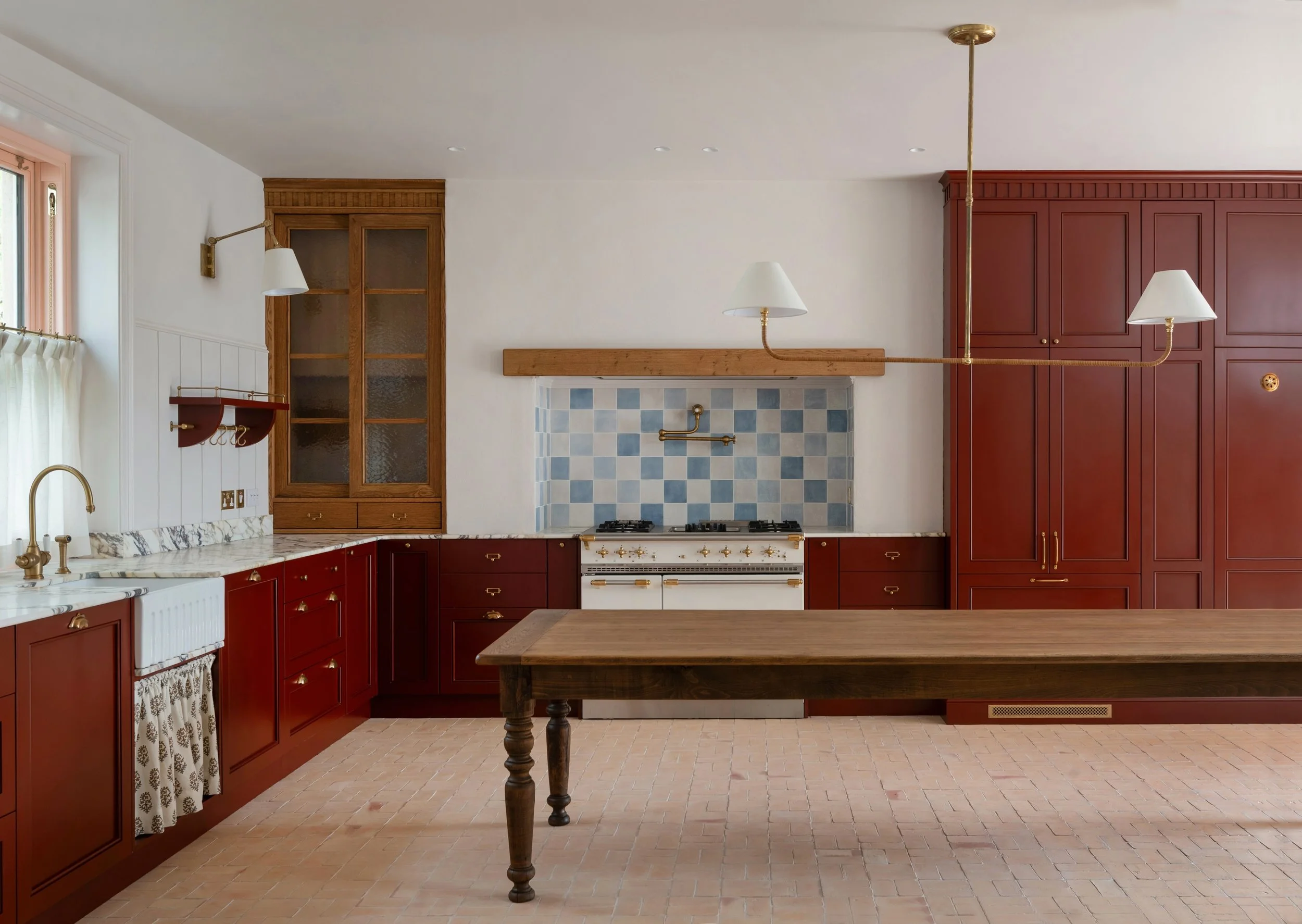 One of the most interesting parts of working in interior architecture and design is creating something completely new within a home that, once finished, feels as though it has always been there.

This kitchen is exactly that. Warm red cabinetry, pink