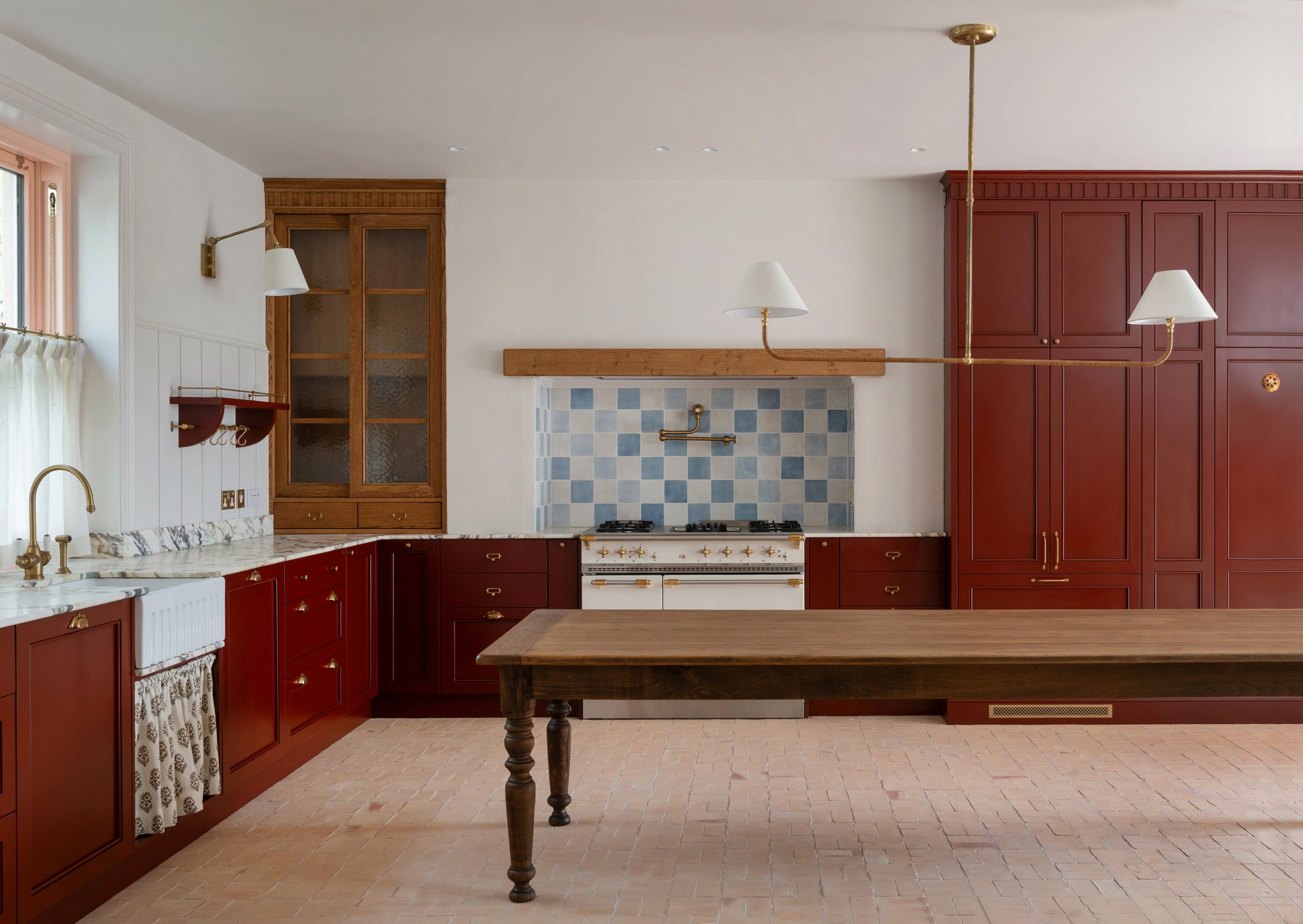 Kitchen at Deerpark Residence in Co. Clare, Ireland, designed by Aoife Maria Interiors with bespoke red cabinetry, oak joinery and marble worktops.