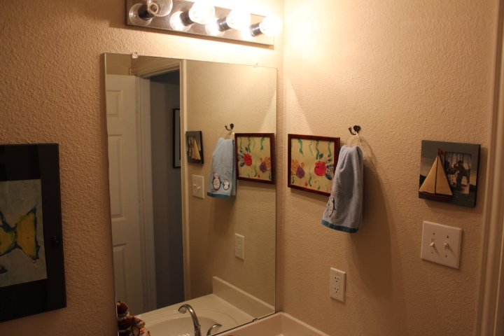 Half Bathroom: Dated fixtures and finishes made the original space feel small, dim, and uninviting (Before)