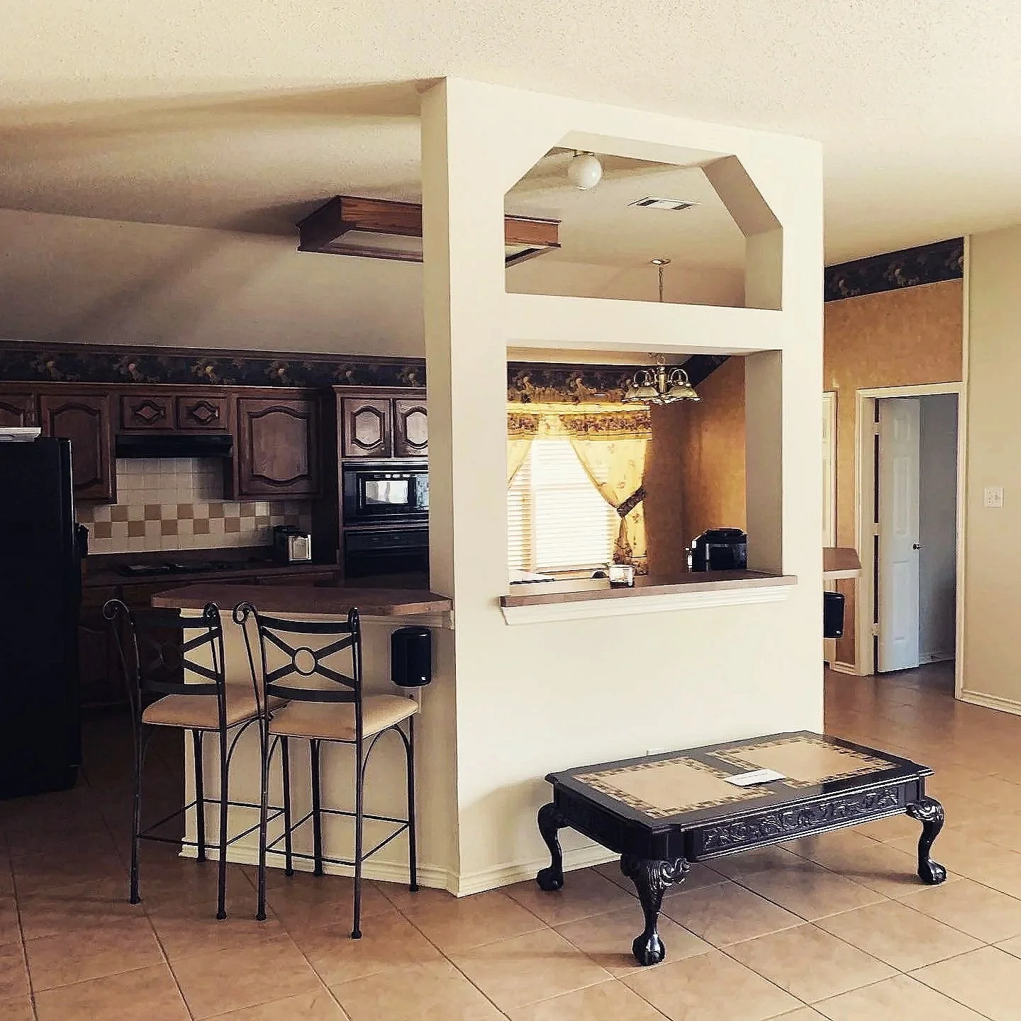Kitchen: Inadequate lighting with dated finishes weighed down the room's aesthetic and obscured its potential for natural light (Before)