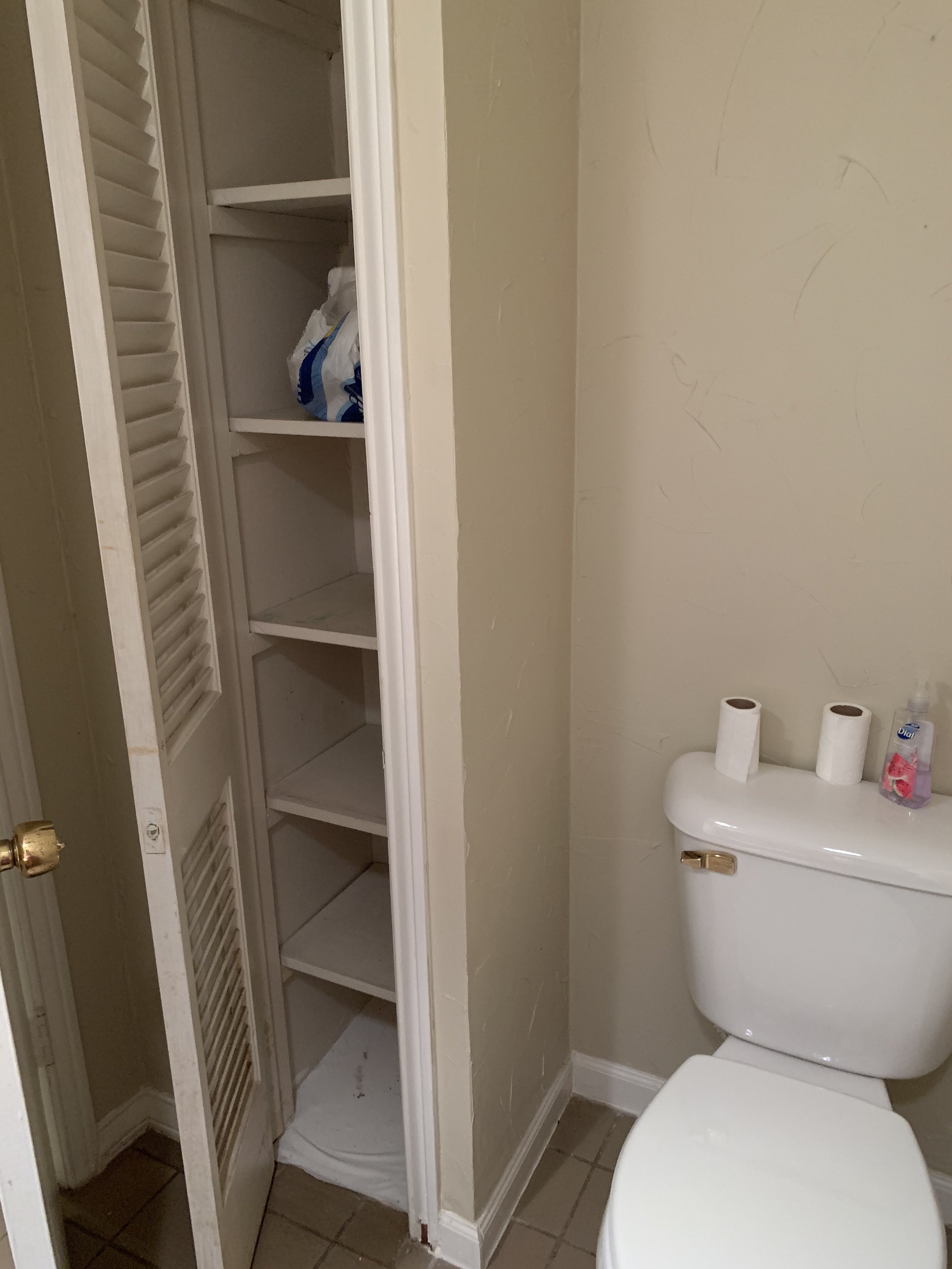 Half Bathroom: Cluttered, nonfunctional shelving and a cramped space (Before)