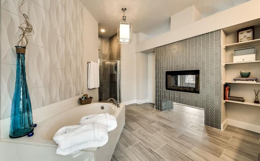 Primary Bathroom: New lighting, cohesive color tones, and wall tiling around fireplace